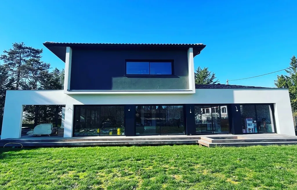 Maison contemporaine bleu nuit et blanche avec grandes baies vitrées noires