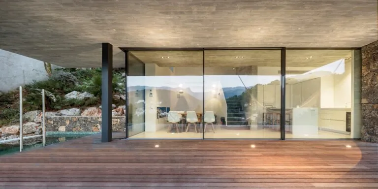 Grande baie coulissante vitrée donnant sur une terrasse en bois